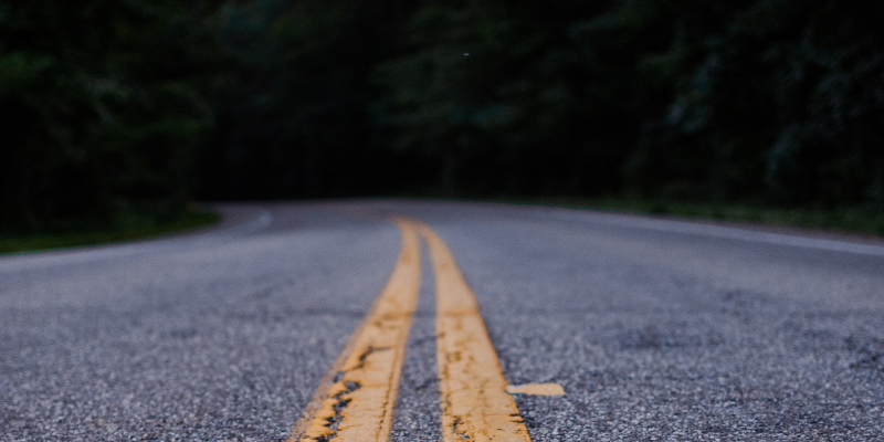 Image of an empty road with trees in the background