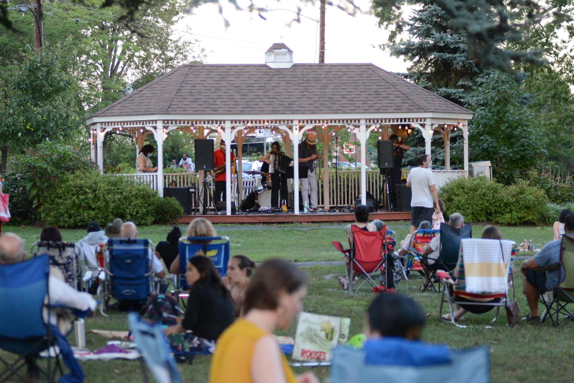 Image of a crowd in lawn chairs watching a band perform at the Springfield Avenue Gazebo.